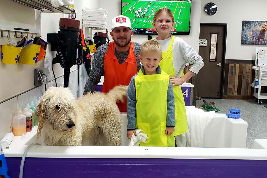 A father and his children after they just washed their dog.